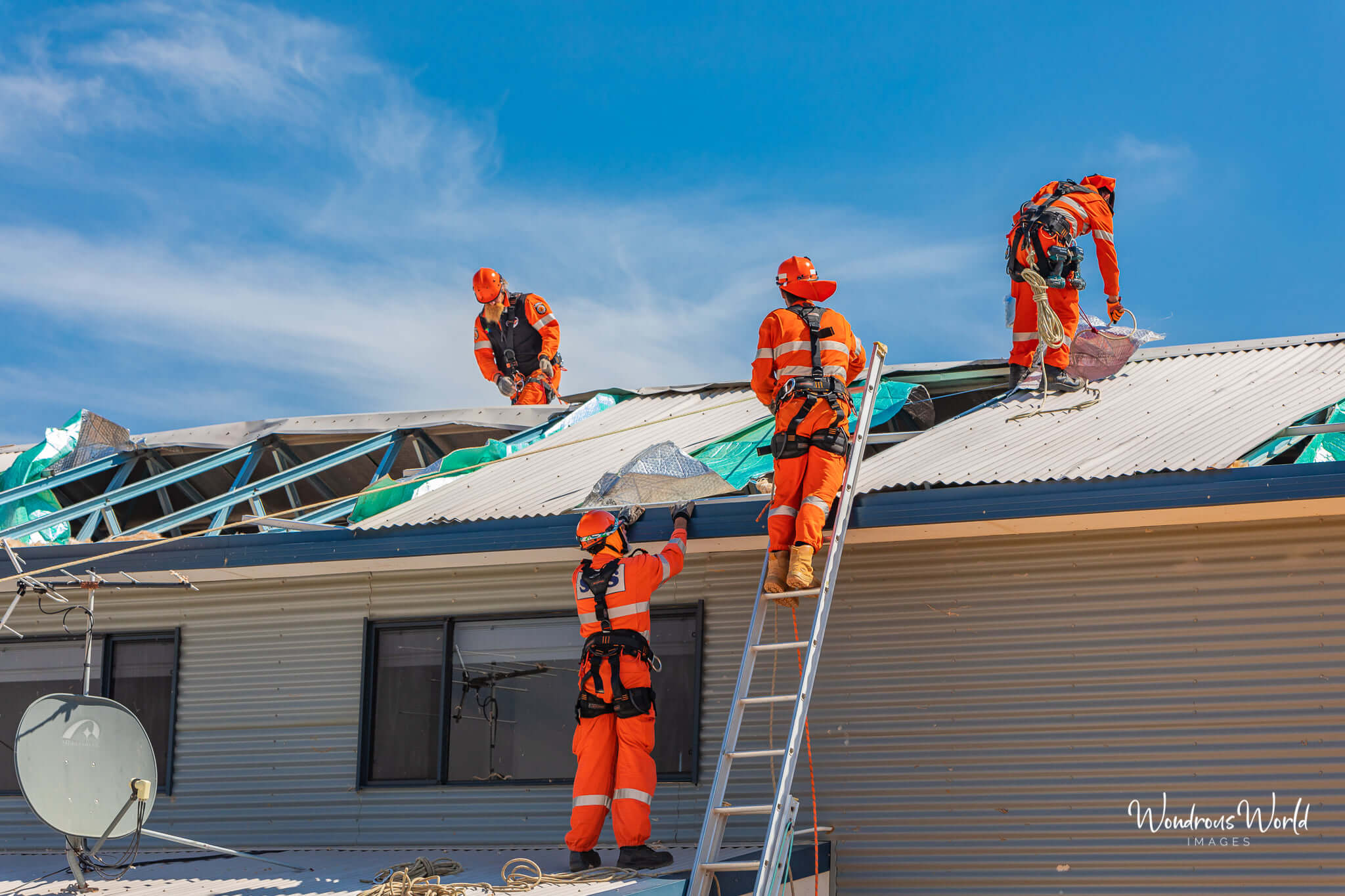 Local SES team repairing the roof of one of the many houses damaged from Seroja